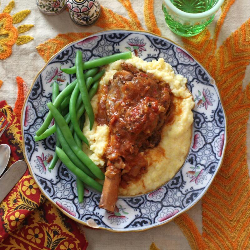 leg of lamb on dinner plate with mashed potato and green beans